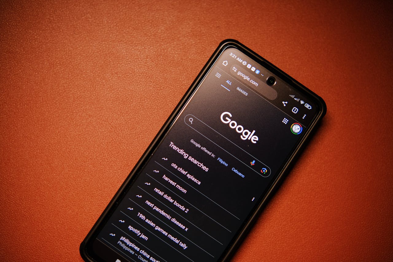 A smartphone displaying Google Search trends on a table at night.